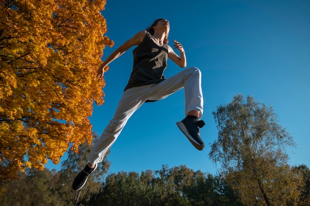 Free photo low angle man jumping outside