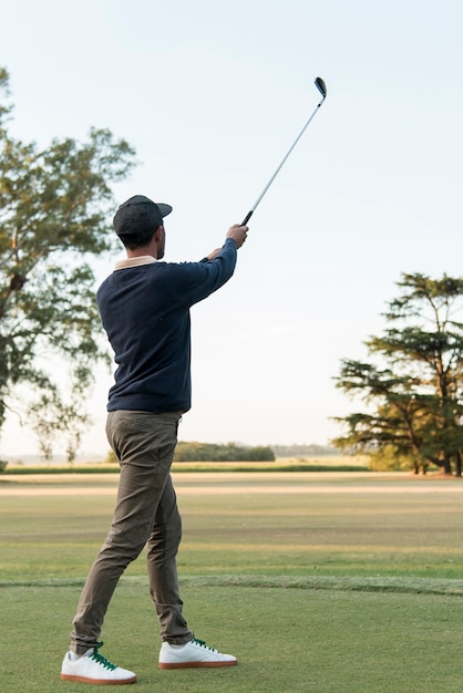 Low angle man playing golf