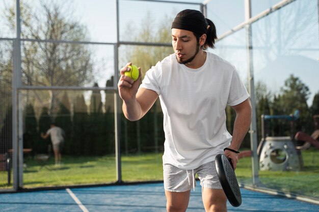 Low angle man playing paddle tennis