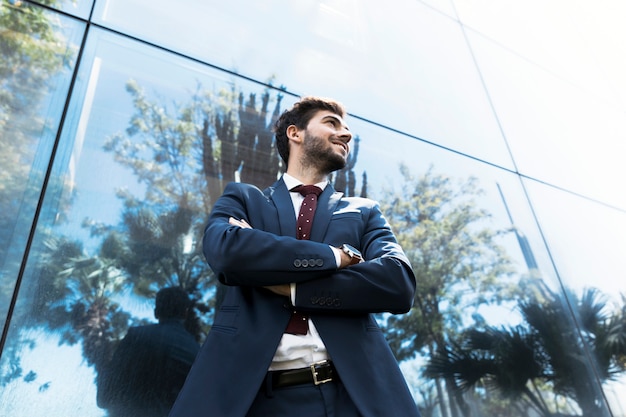 Low angle man standing with crossed arms