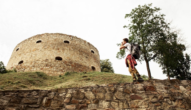 Free photo low angle man taking photos of castle