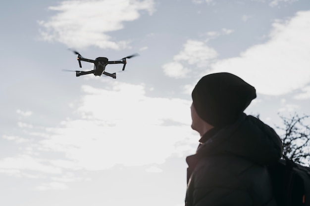 Free photo low angle man watching drone