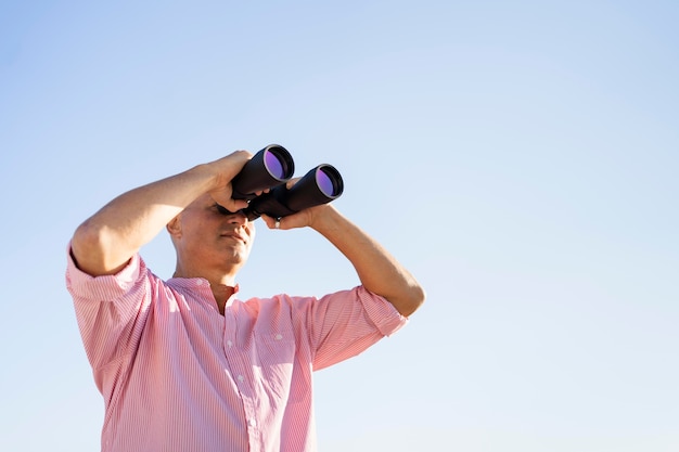 Free Photo low angle man watching through binocular