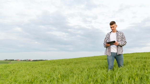 Free Photo low angle man with tablet at farm