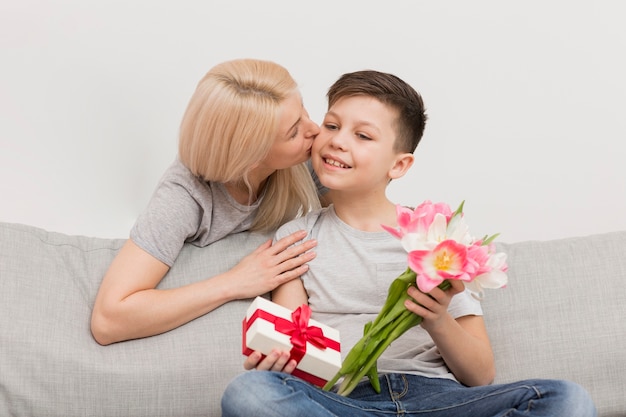 Low angle mother kissing son for gifts