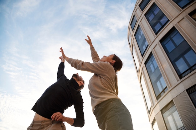 Free Photo low angle people dancing together outdoors