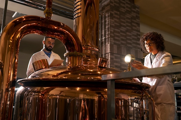 Free photo low angle people working in beer factory