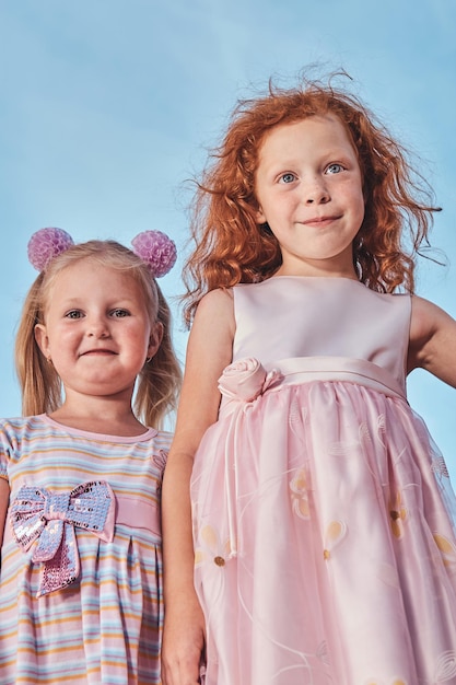 Free photo low angle portrait of happy cute little friends against the sky background.