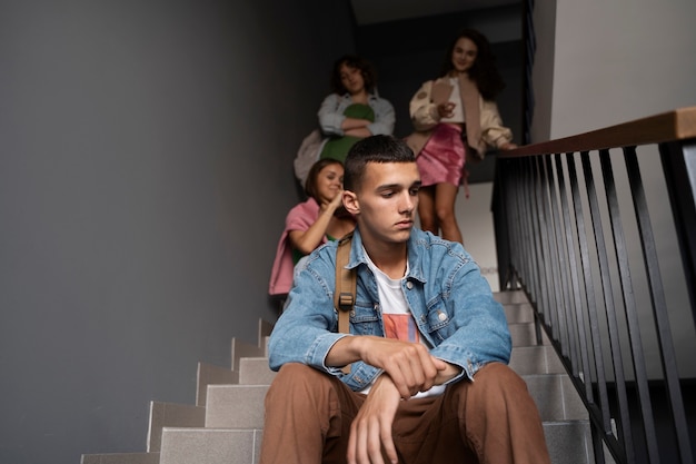 Low angle sad boy being bullied on stairs