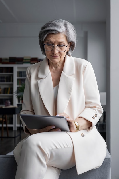 Low angle senior woman holding tablet