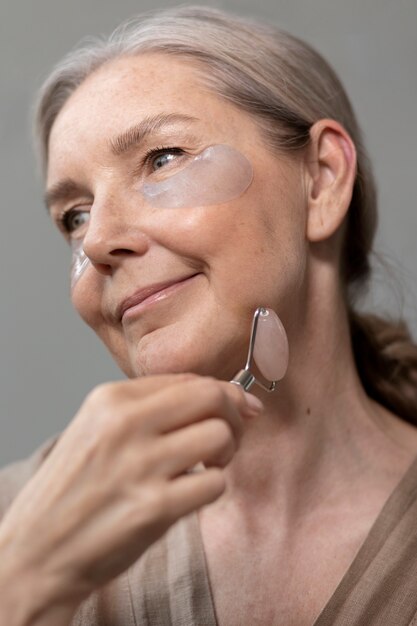 Low angle senior woman massaging face