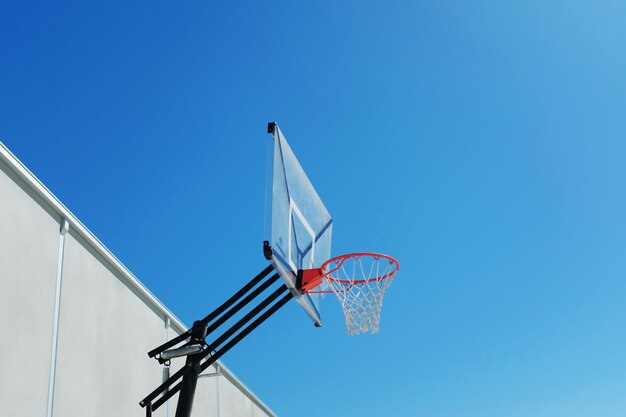 Low angle shot of a basketball hoop under the beautiful clear sky