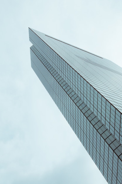 Free photo low angle shot of a beautiful glass modern skyscraper with blue sky