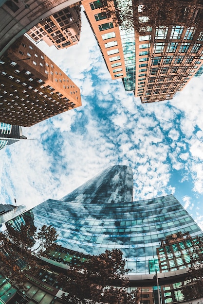 Free photo low angle shot of the beautiful high skyscrapers under the blue cloudy sky