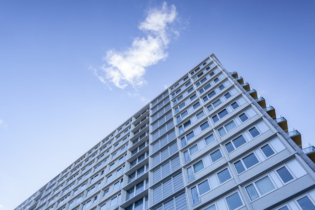 Low angle shot of a big building under a cloud in the beautiful blue sky