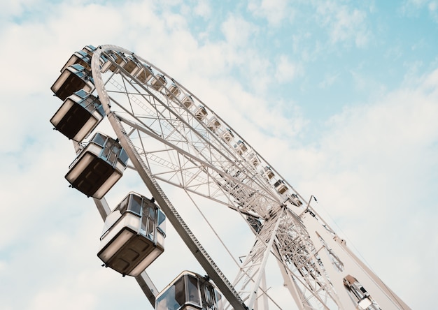 Free Photo low angle shot of a ferris wheel with cloudy blue sky