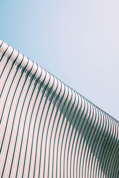 Free Photo low angle shot of a grey and white building roof with interesting textures under the blue sky