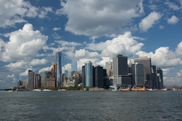 Free photo low angle shot of an industrial city with skyscrapers at the edge of a sea and under the cloudy sky