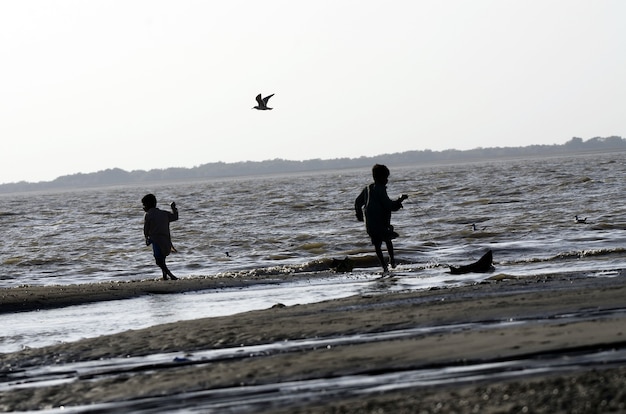 Low angle shot of kids walking on the beach