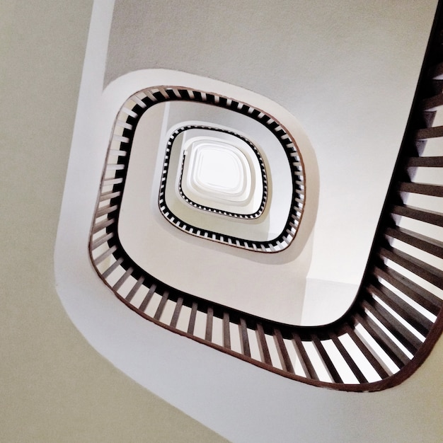 Free photo low angle shot of a modern spiral staircase in white