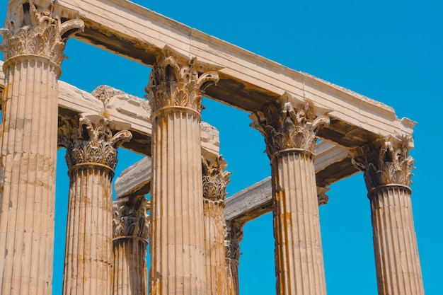 Low angle shot of old greek stone pillars with a clear blue sky