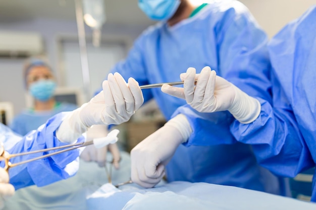 Free photo low angle shot in the operating room assistant hands out instruments to surgeons during operation surgeons perform operation professional medical doctors performing surgery