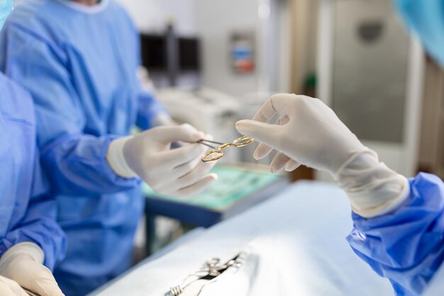 Low Angle Shot in the Operating Room Assistant Hands out Instruments to Surgeons During Operation Surgeons Perform Operation Professional Medical Doctors Performing Surgery