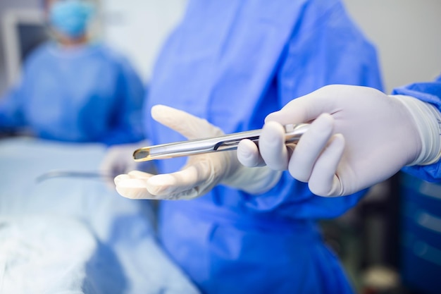 Free Photo low angle shot in the operating room assistant hands out instruments to surgeons during operation surgeons perform operation professional medical doctors performing surgery