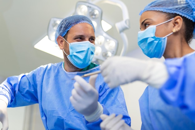 Free Photo low angle shot in the operating room assistant hands out instruments to surgeons during operation surgeons perform operation professional medical doctors performing surgery