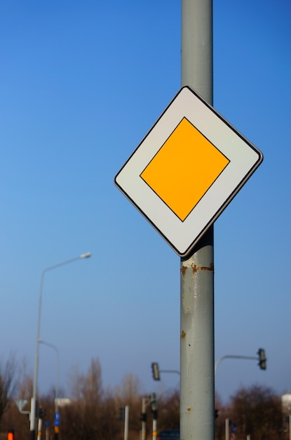 Free photo low angle shot of a priority traffic sign under a clear blue sky