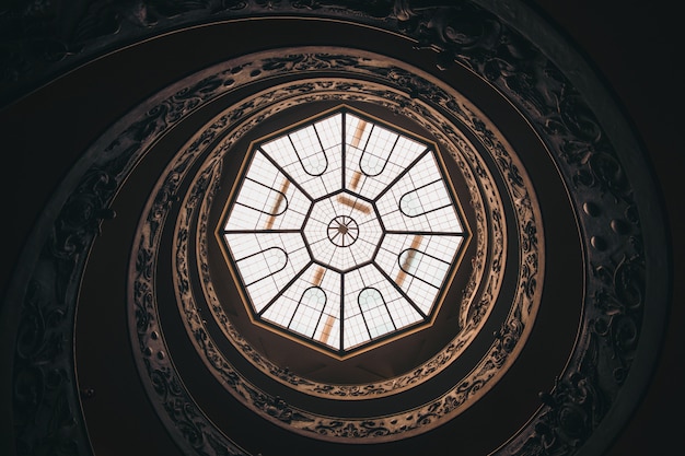 Free Photo low angle shot of a round ceiling with a window in a museum in vatican during daytime