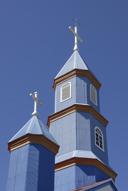 Free photo low angle shot of a small blue church under a blue and clear sky