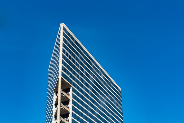 Low angle shot of tall glass buildings under a cloudy blue sky