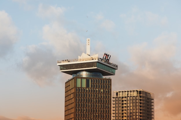 Free photo low angle shot of a tall historic building under a cloudy sky in amsterdam