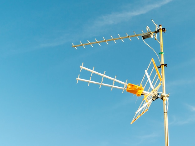 Free Photo low angle shot of a television antenna captured on a sunny day with a clear sky