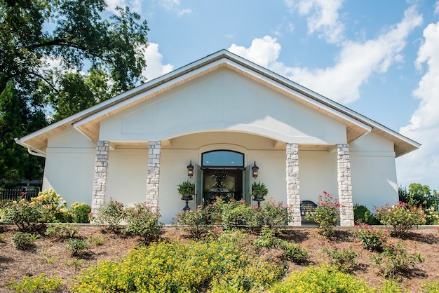 Low angle shot of a white church with a beautiful flower garden