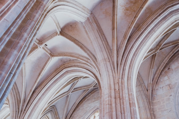 Low angle shot of the white columns and the ceiling of an old building