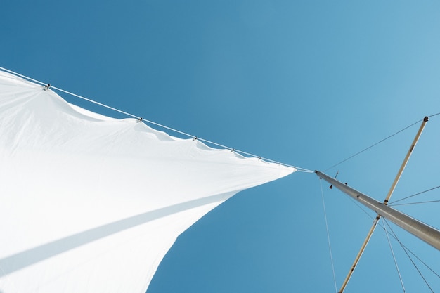 Free Photo low angle shot of a white sail on boat mast under clear sky during daytime