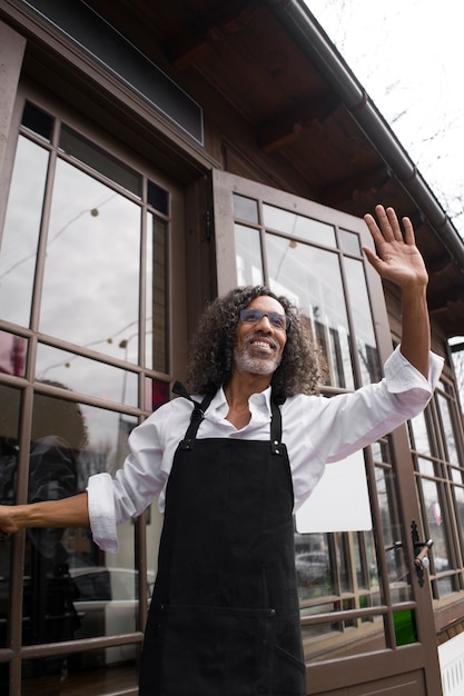 Low angle smiley business owner saluting someone