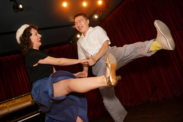 Low angle smiley couple swing dancing