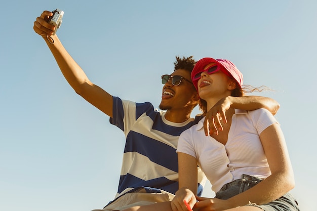 Free photo low angle smiley friends taking selfie