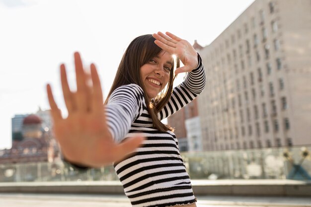 Low angle smiley woman posing outside