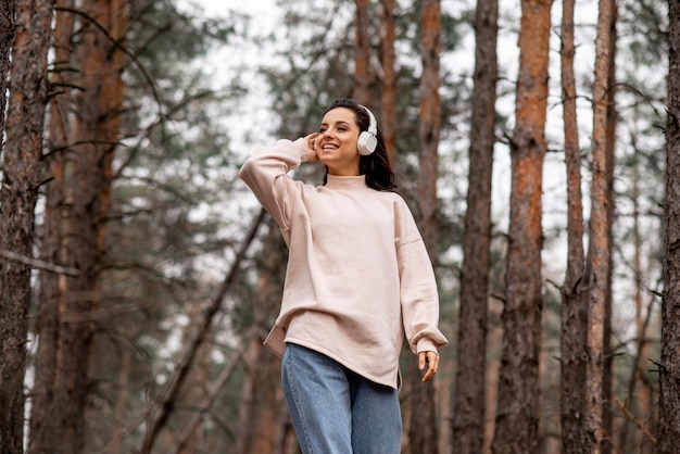 Low angle smiley woman with headphones