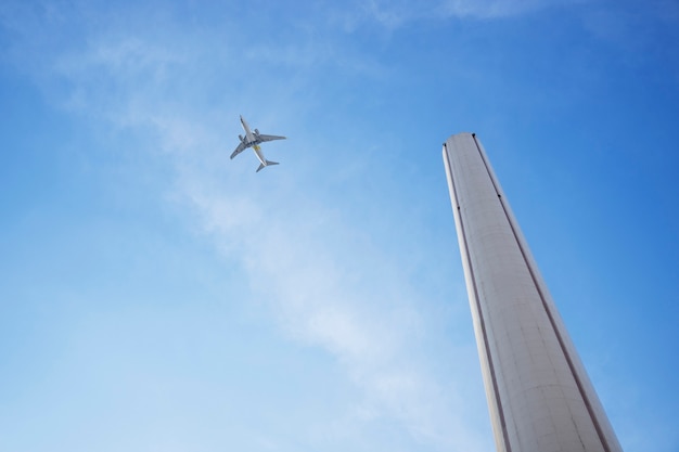 Free Photo low angle tall chimney and airplane