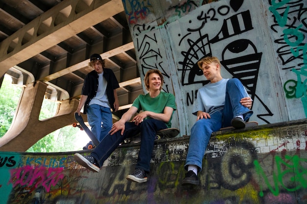 Free Photo low angle teens with skateboards outdoors