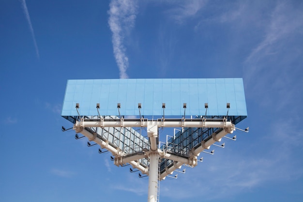 Low angle view of blue big hoarding pole with light against blue sky