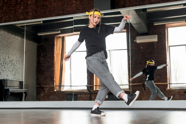 Free Photo low angle view of female dancer dancing in the studio