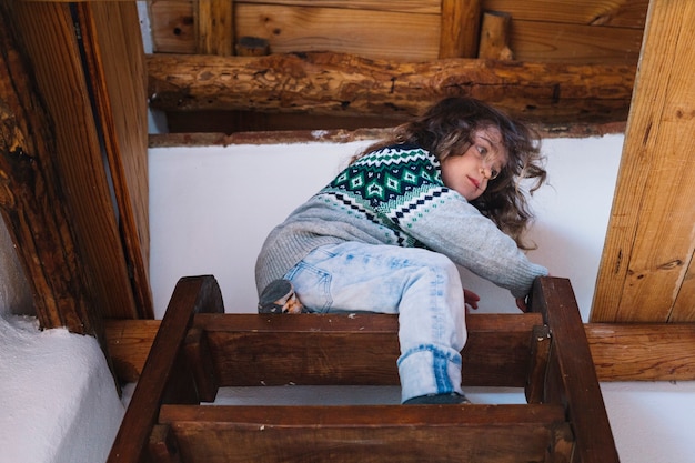 Low angle view of a girl sitting on top of the staircase