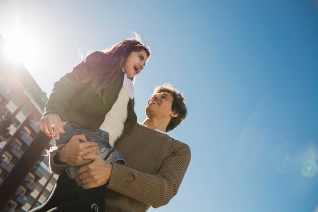 Low angle view of a happy father carrying his daughter