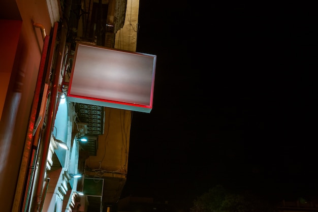 Free photo low angle view of illuminated billboard on residential building against sky